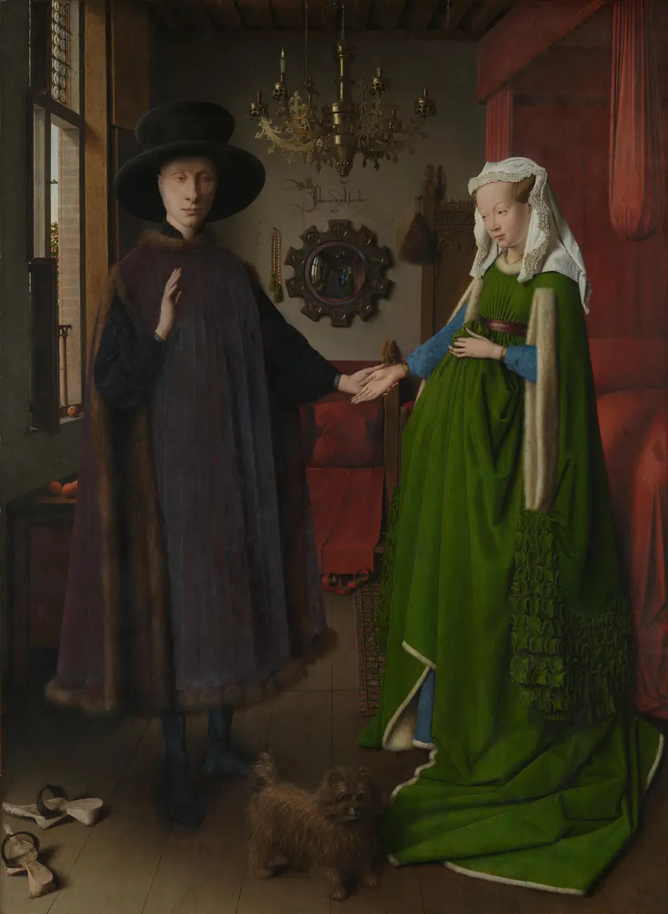A man in a dark fur-trimmed robe and a woman in a green dress hold hands in a room with a chandelier, a small dog and a round mirror on the back wall.