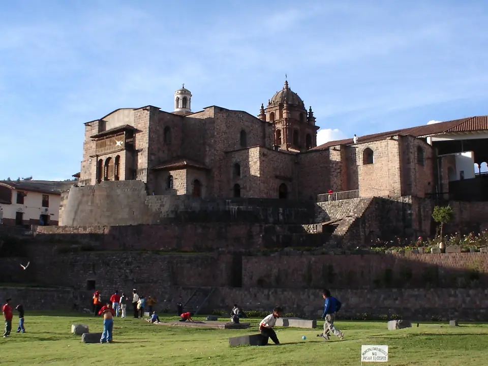 A colonial church and convent built on top of a curved wall of finely fitted stone blocks.