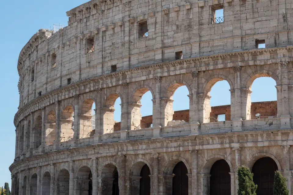A huge oval stone amphitheater with stacked rows of arches, partly ruined on one side.