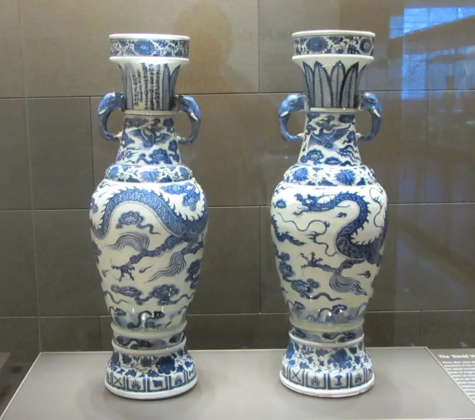 A pair of tall blue-and-white porcelain vases with dragons, elephant-head handles and inscriptions on the necks.