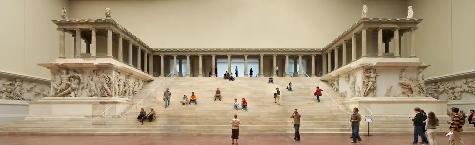 A reconstructed monumental marble altar with a wide staircase between colonnaded wings, its base wrapped by a frieze of battling figures.