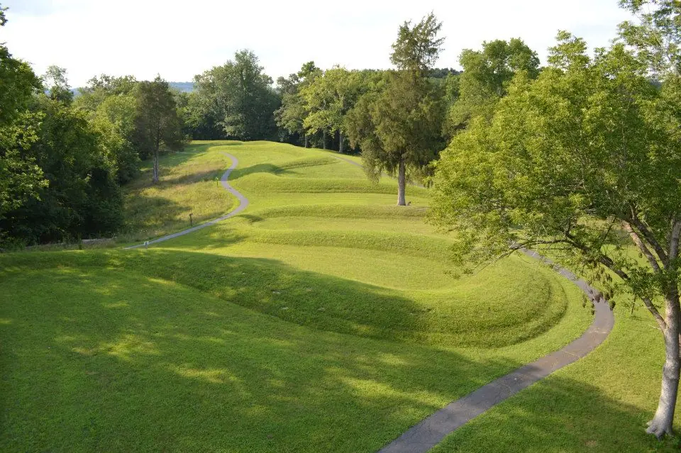 A long, curving earthen mound shaped like a snake on a grassy ridge.