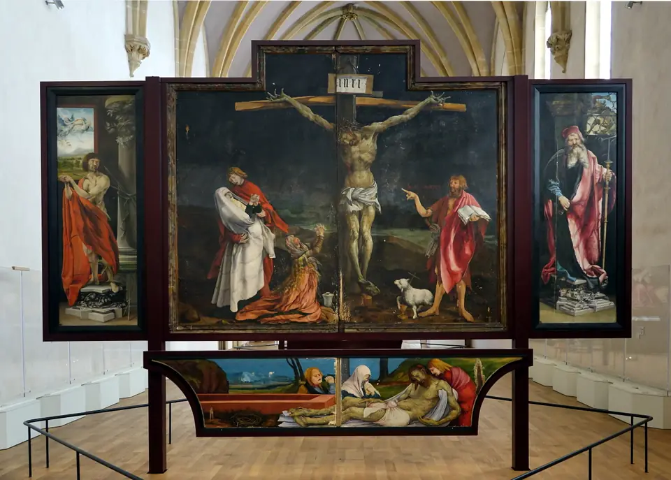 An altarpiece showing a crucified figure with a twisted, sore-covered body, mourners at the left and a pointing figure at the right.