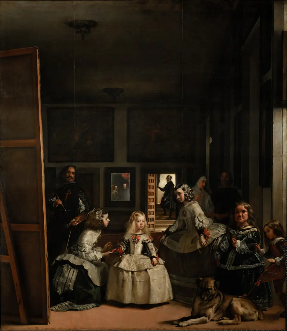 A large room in which a young girl in a wide dress stands among attendants, with a painter at a tall canvas at left and a mirror on the back wall.