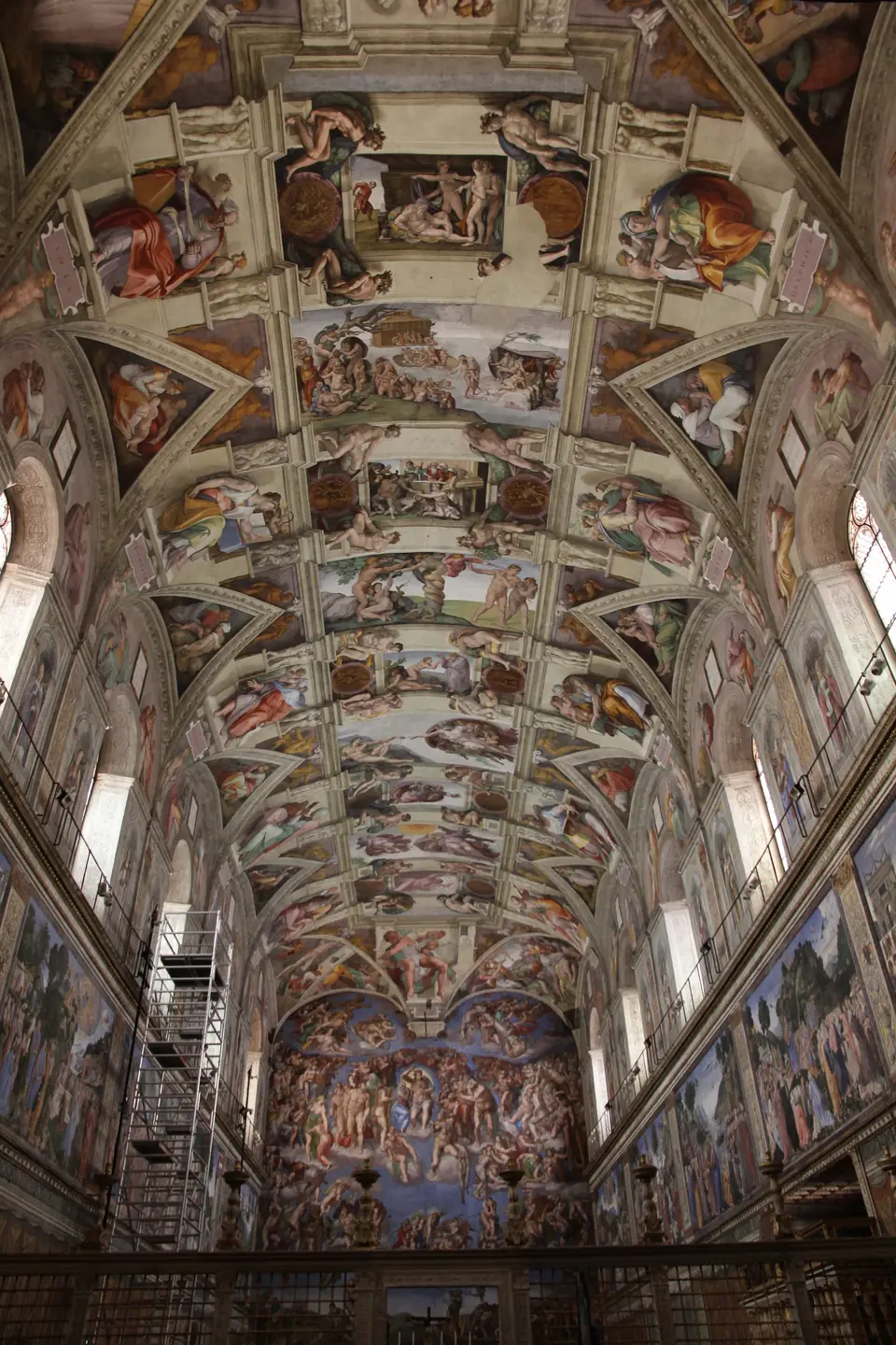 A long vaulted ceiling painted with framed scenes, seated prophets and many nude figures.