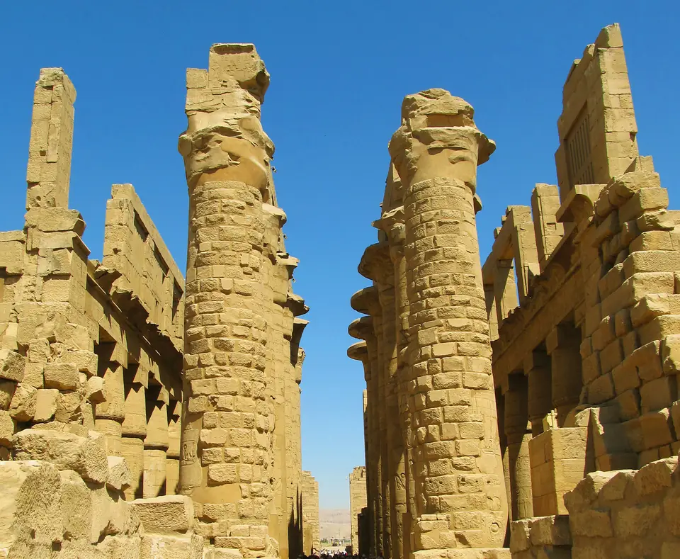 Massive carved stone columns crowded closely together in a roofless hall.