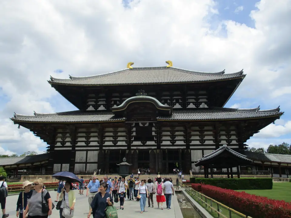 A massive wooden temple hall with a sweeping double tiled roof.